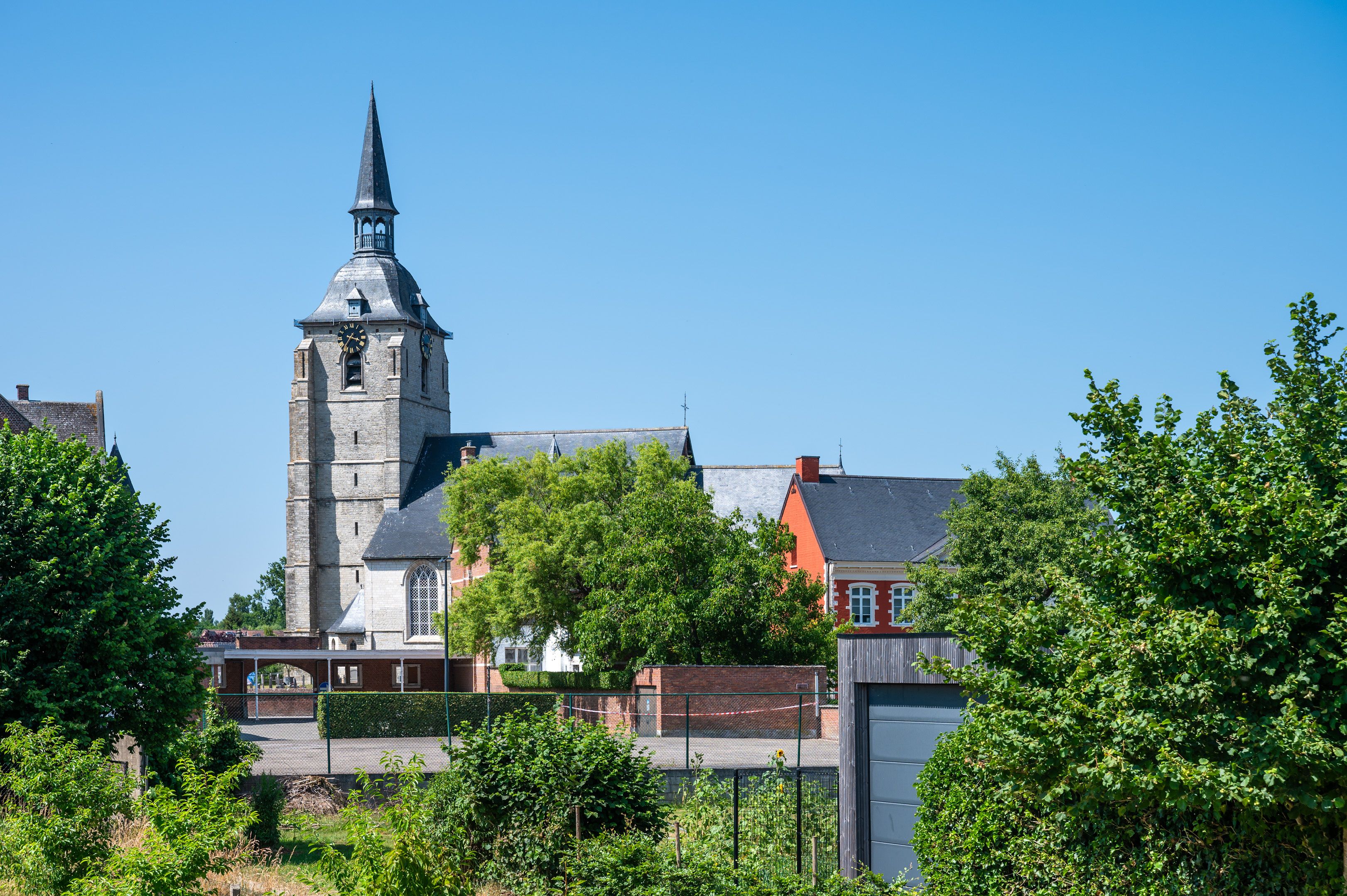 Una iglesia con un campanario alto y una torre del reloj.