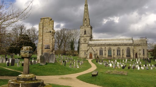 St George's parish church, Ticknall, Derbyshire, seen from the south. On the left in the foreground is the truncated Medieval churchyard cross. Centre left between the cross and St George's church is the ruin of the tower of the Medieval church of St Thomas Becket. St Thomas Becket's was demolished when St George's was built.