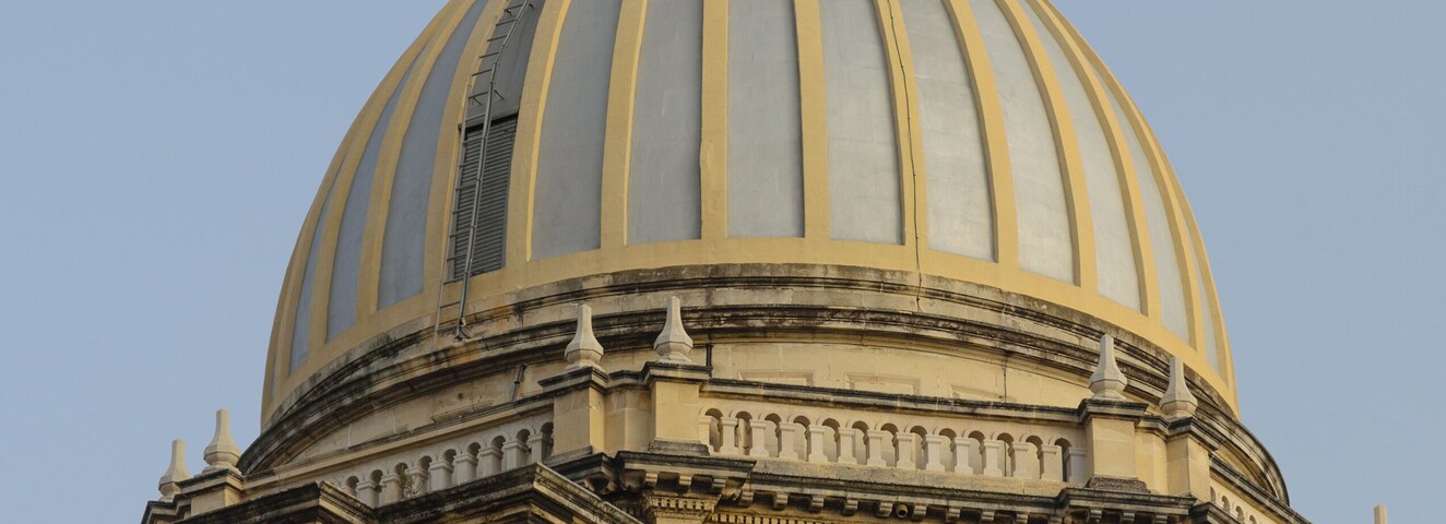 A large, ornate dome with a cross on top, part of a historic building.
