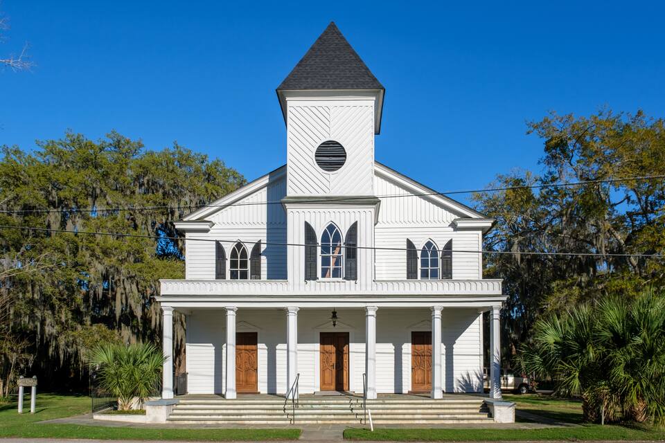 A white church with a steeple and arched windows.