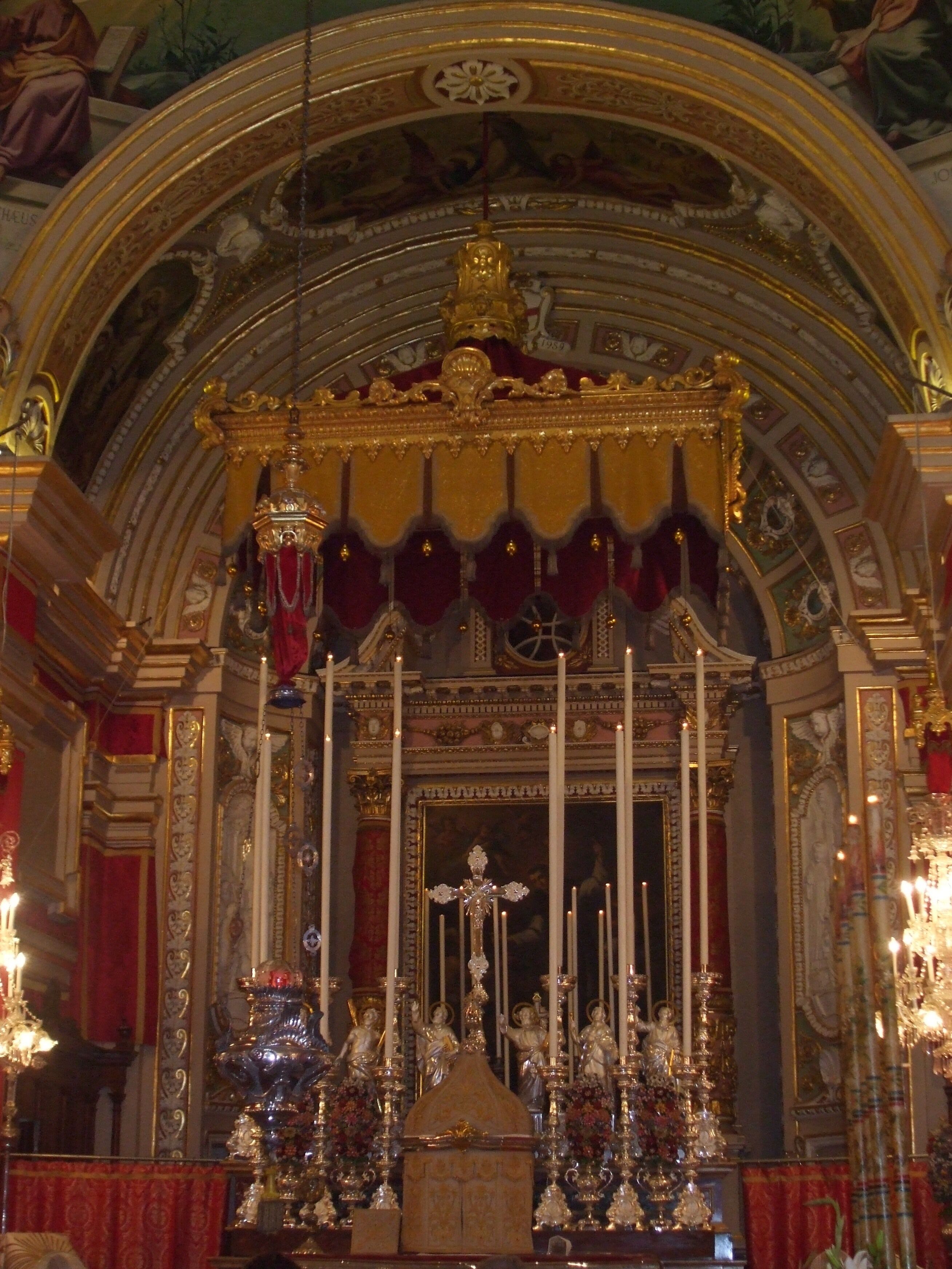 An ornate religious altar with golden decorations, statues, and candles.