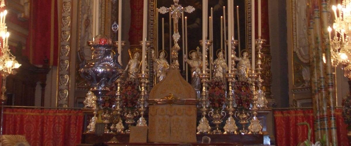 An ornate religious altar with golden decorations, statues, and candles.