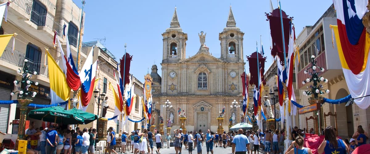 A bustling street with a historic church in the background.