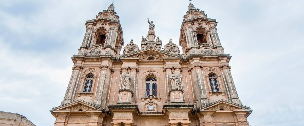A historic church with ornate architecture, including a large central door and two bell towers.
