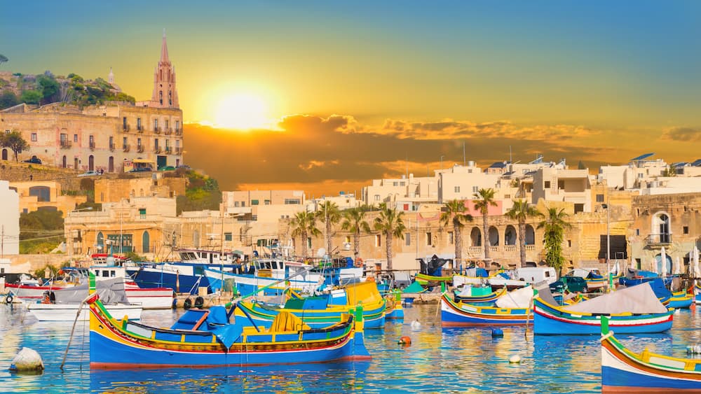 Marsaxlokk bay harbour of Malta, with beautiful architecture and boats at dusk