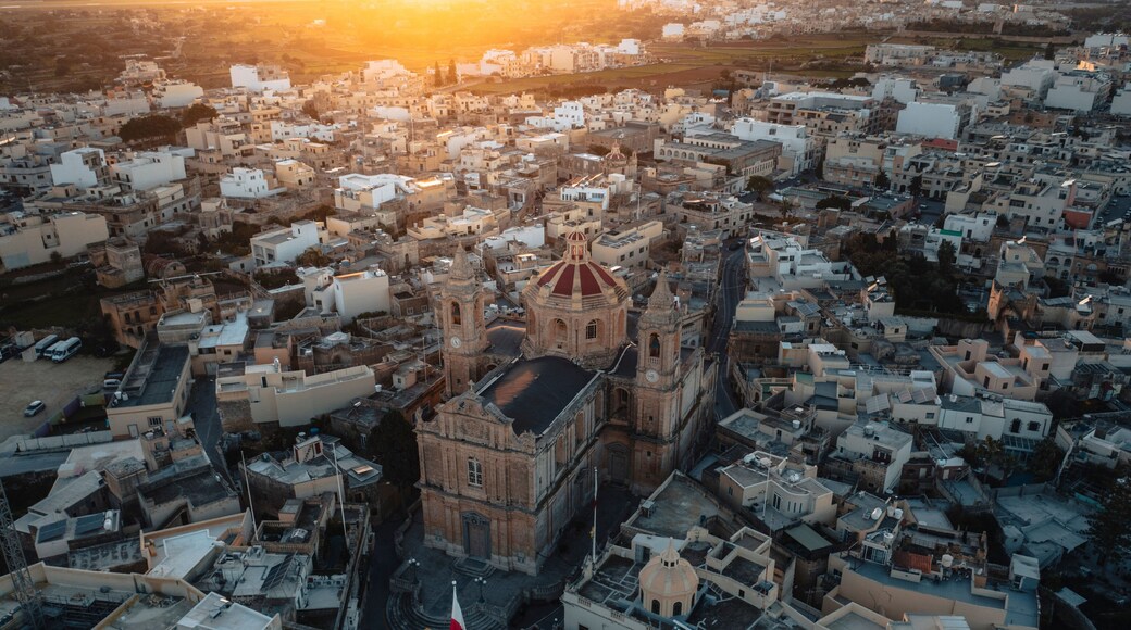 Aerial view of the historic parish church of Mellieha surrounded by charming rooftops at sunset, Ghaxaq, Malta.