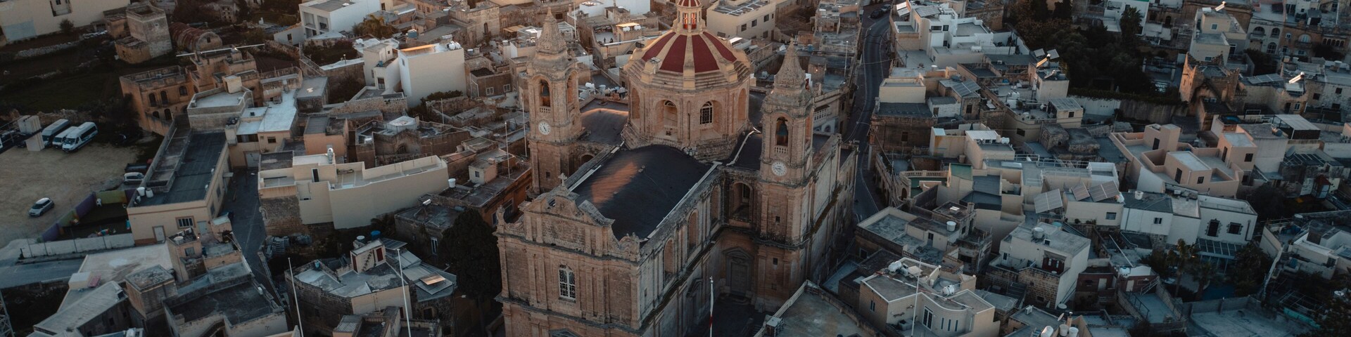 Aerial view of the historic parish church of Mellieha surrounded by charming rooftops at sunset, Ghaxaq, Malta.