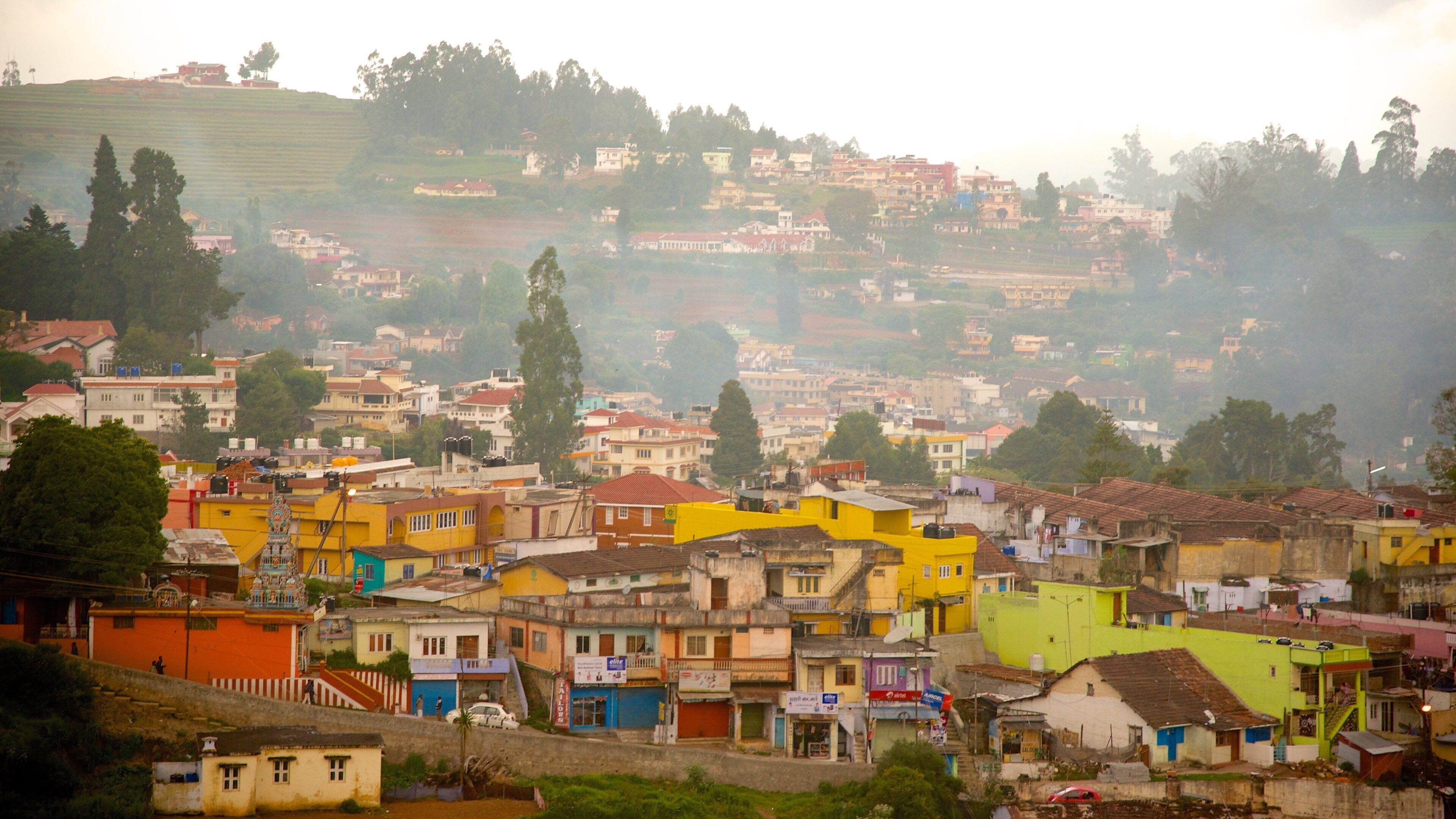 A densely populated hillside town with colorful buildings and a hilly backdrop.