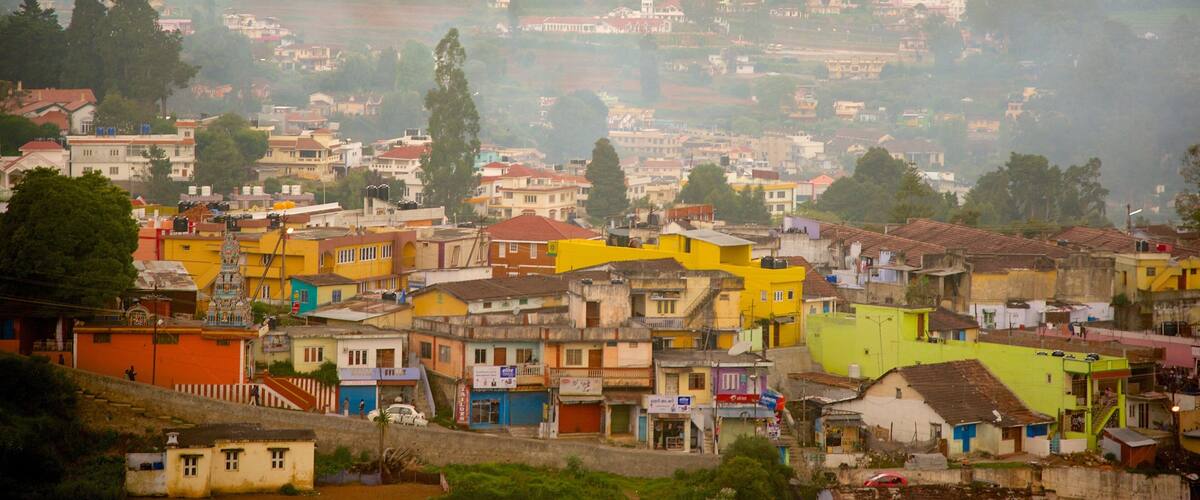 A densely populated hillside town with colorful buildings and a hilly backdrop.