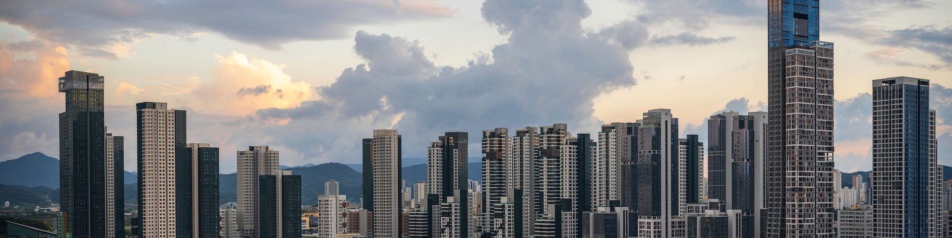 Sejong City Panoramic Skyline and tall buildings at sunset with dramatic clouds with warm glow over skyscrapers