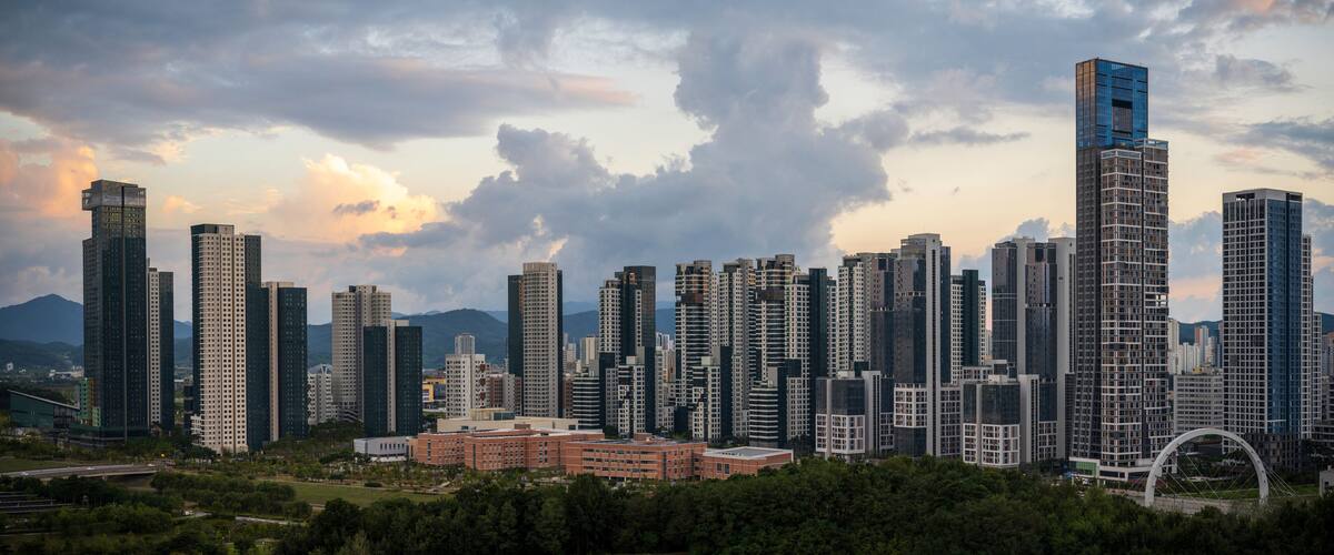 Sejong City Panoramic Skyline and tall buildings at sunset with dramatic clouds with warm glow over skyscrapers