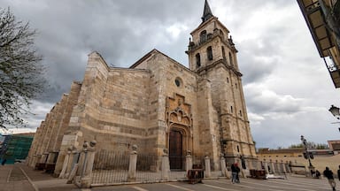Uma igreja histórica com uma alta torre de sino e uma grande porta de madeira.