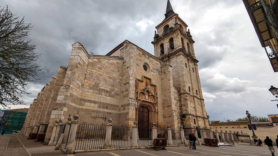 A historic church with a tall bell tower and a large wooden door.