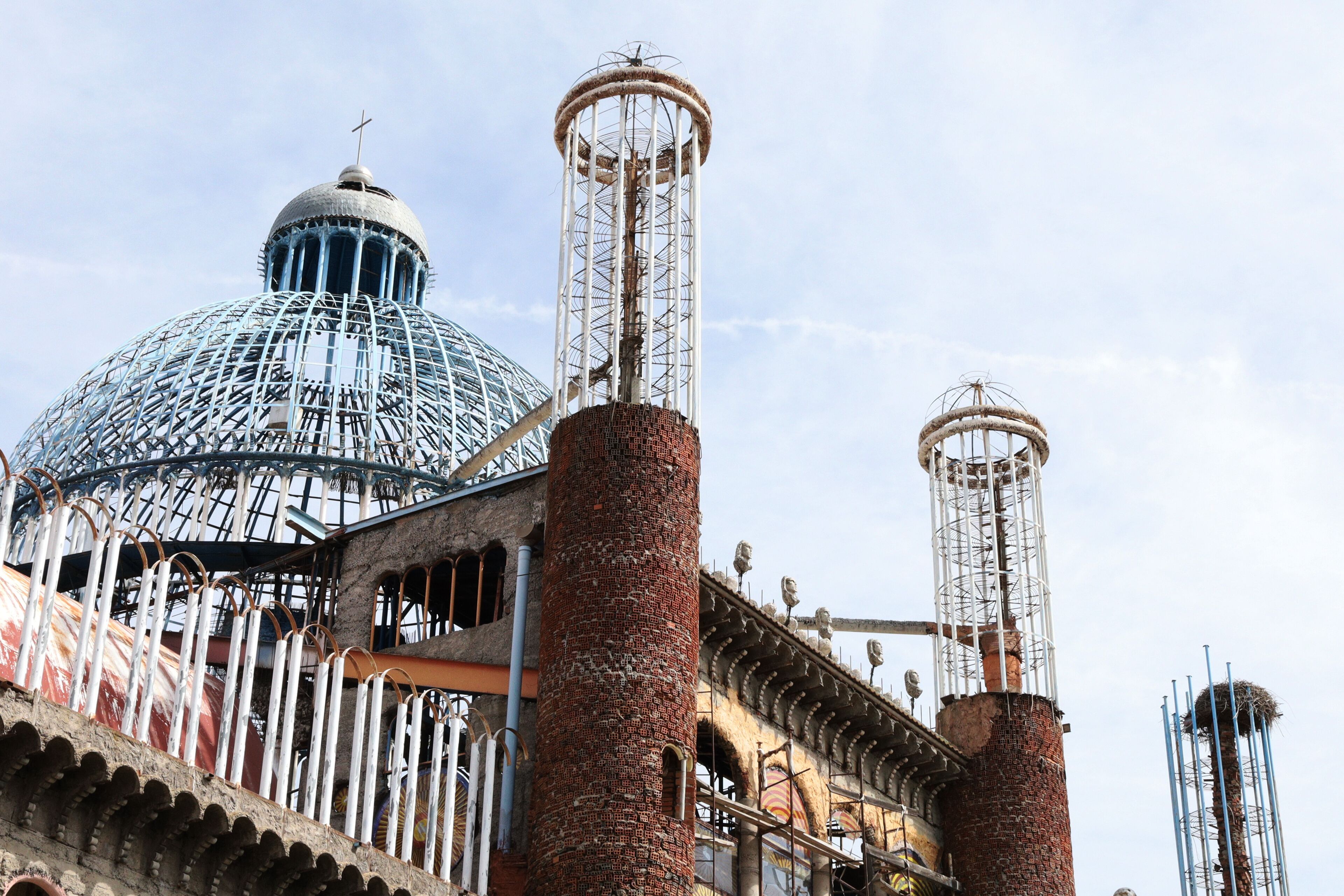 A historic building with a large dome and two tall chimneys.