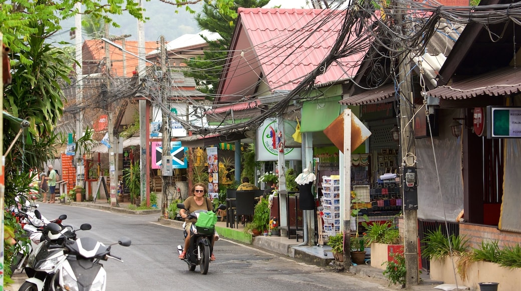 Surat Thani showing motorcycle riding and a small town or village as well as an individual femail