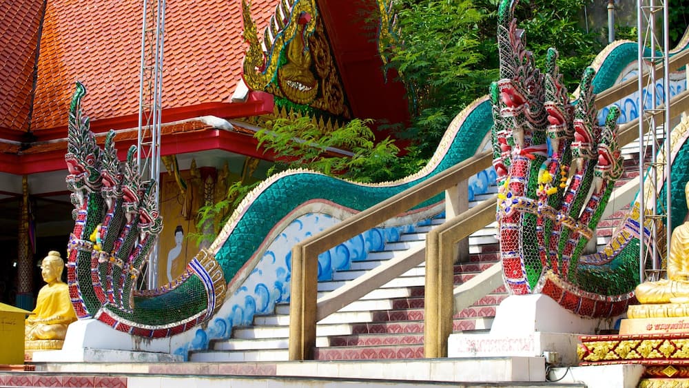 A temple staircase with colorful decorations and a golden statue.
