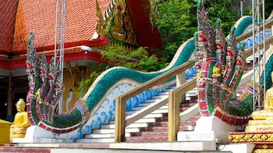 A temple staircase with colorful decorations and a golden statue.