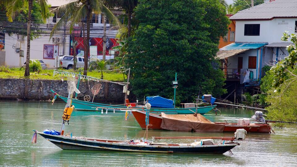 A calm river with several boats docked along the shore.