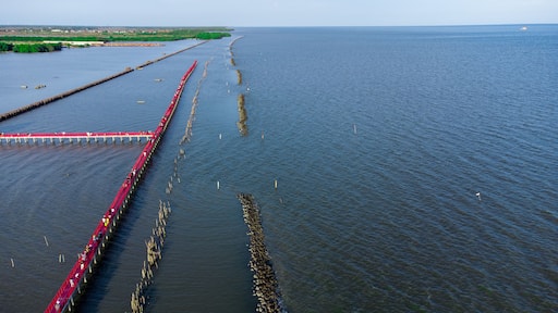 Photo on drone with Beautiful wooden long red bridge at seaside of samut sakhon province,Thailand. Locate on dolphin view point called mutshanu shring.