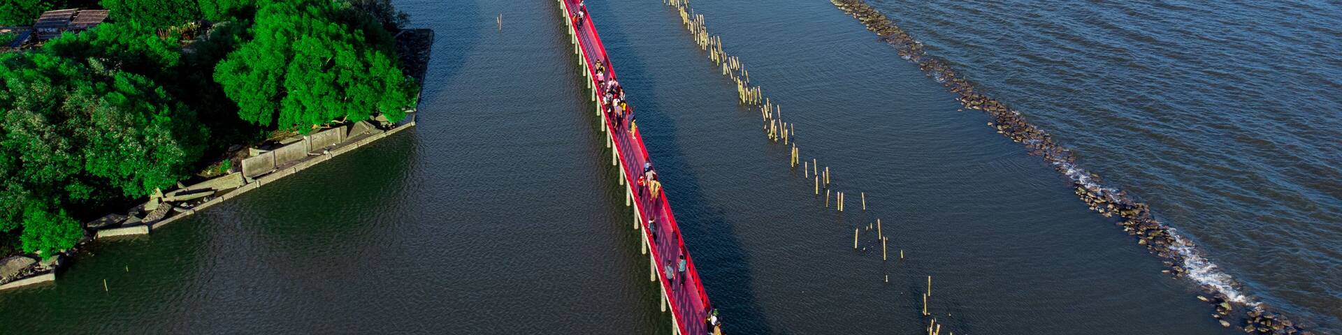 Photo on drone with Beautiful wooden long red bridge at seaside of samut sakhon province,Thailand. Locate on dolphin view point called mutshanu shring.