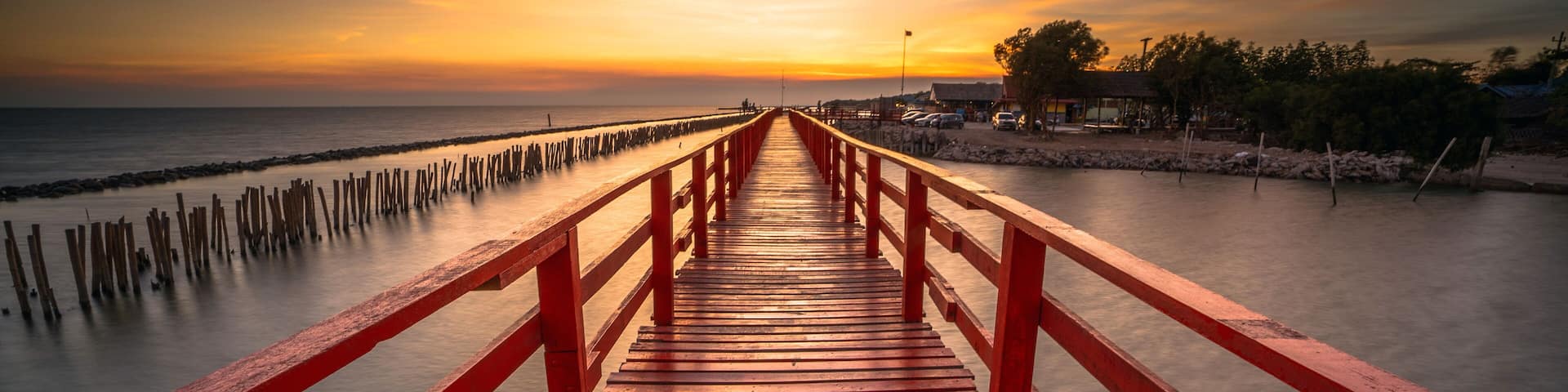 Red bridge in the evening with a beautiful sunset, Dolphin viewpoint, Samut Sakhon, Thailand.