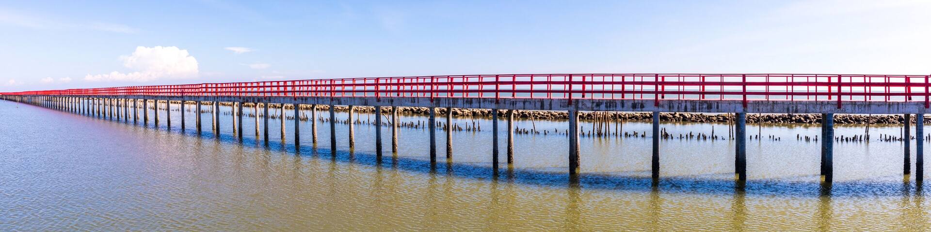Beautiful landscape photo of red long wooden bridge with blue sky in Samut Sakhon province, Thailand. Asia. panorama landscape photo.