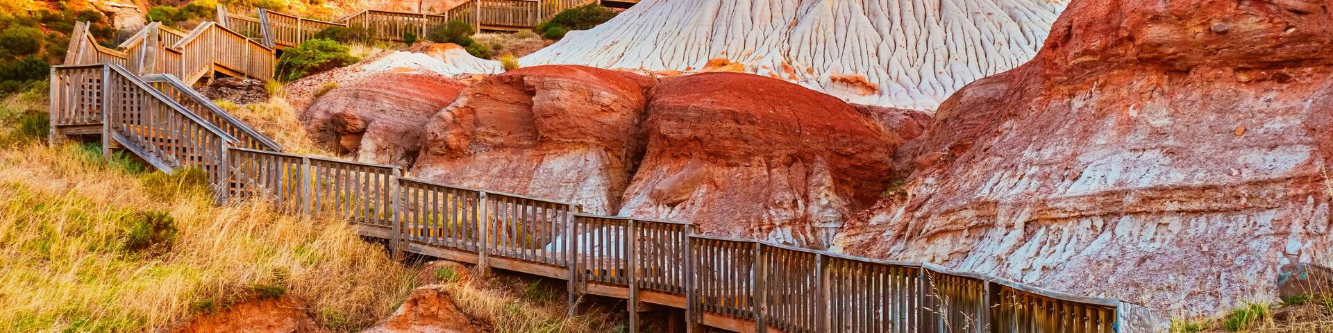 Walking trail with wooden stairs around the Hallett Cove Sugarloaf at sunset