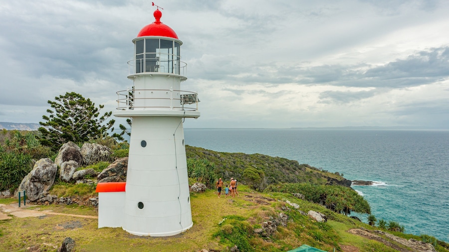 Double Island Point Conservation Park featuring general coastal views and a lighthouse as well as a small group of people
