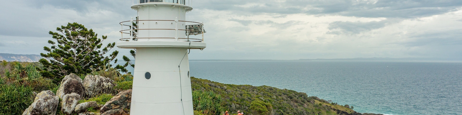 Double Island Point Conservation Park featuring general coastal views and a lighthouse as well as a small group of people