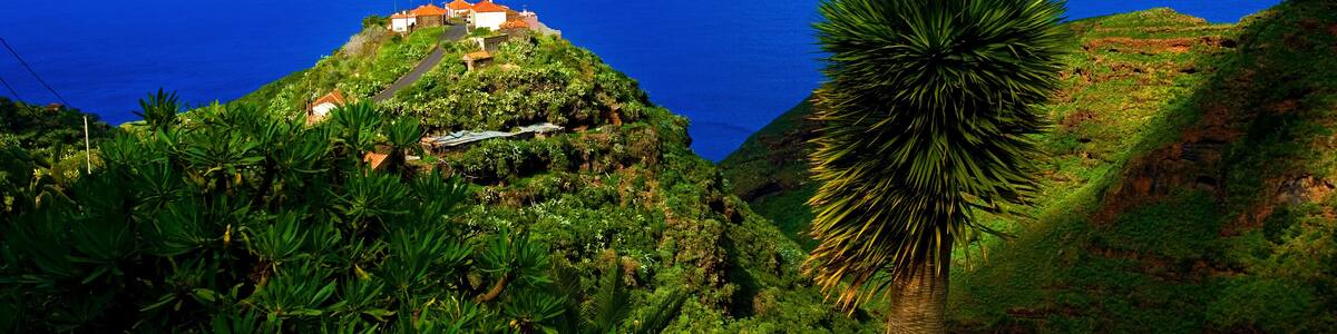 View of a lonely remote farmstead near Barlovento, on the top of a hill with a play of shadows, rugged terrain high above the blue Atlantic, La Palma, Canary Islands, Spain
