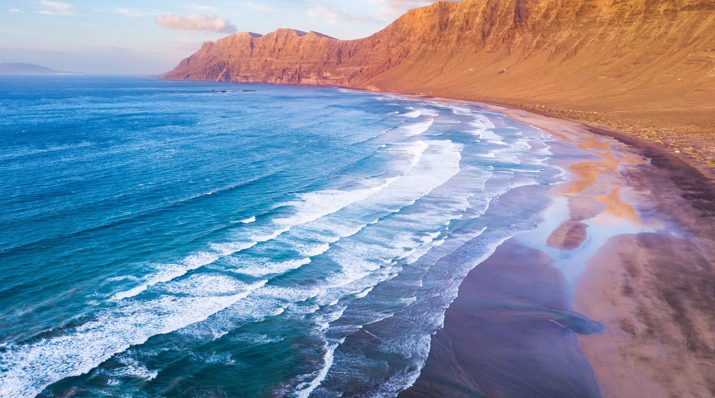 Famara Atlantic ocean beach surf spot aerial view of scenic landscape from drone in Lanzarote, Canary islands during warm sunny summer day, vacation holidays destination for surfing near La Santa