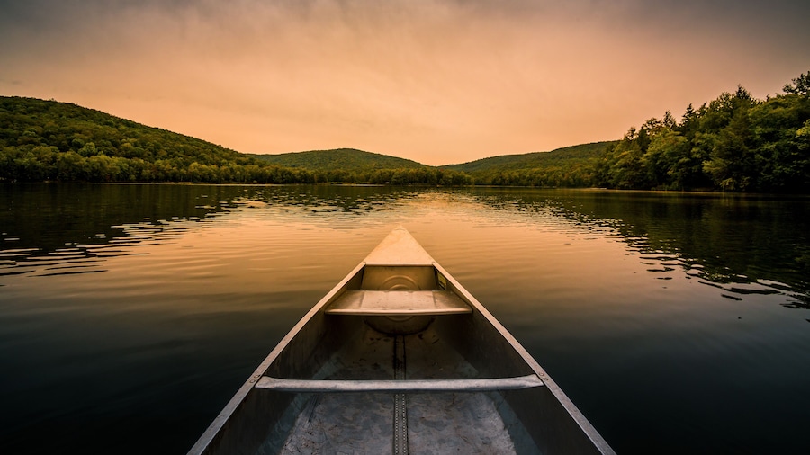 Aluminum canoe on a mountain lake upstate New York. Camping. outdoors and adventure concept. Faded, vintage color post processed