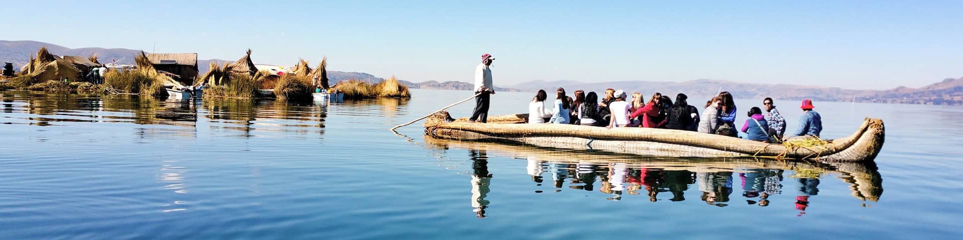 One of the many Uros (reed) floating islands with a totora boat in the early morning at Lake Titicaca
