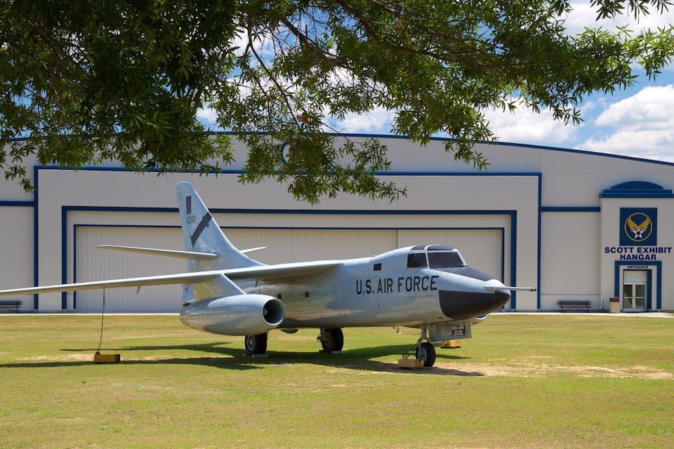 A U.S. Air Force plane parked in front of a hangar.