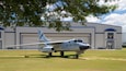Un avión de la Fuerza Aérea estadounidense estacionado frente a un hangar.
