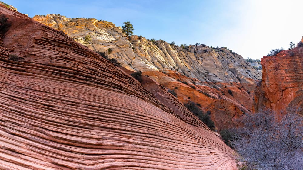 Eine rote Felsformation mit deutlichen Schichtungen und einer steilen Klippe im Hintergrund.