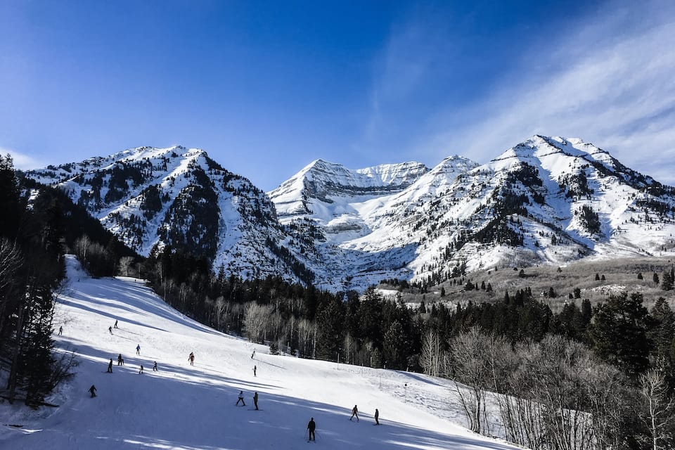 Ein verschneites Gebirge mit Skifahrern am Hang.
