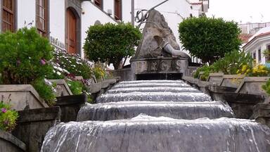 Una escalera de piedra que conduce a una fuente con una escultura de un pájaro y la palabra 'FIRAS' escrita en ella.