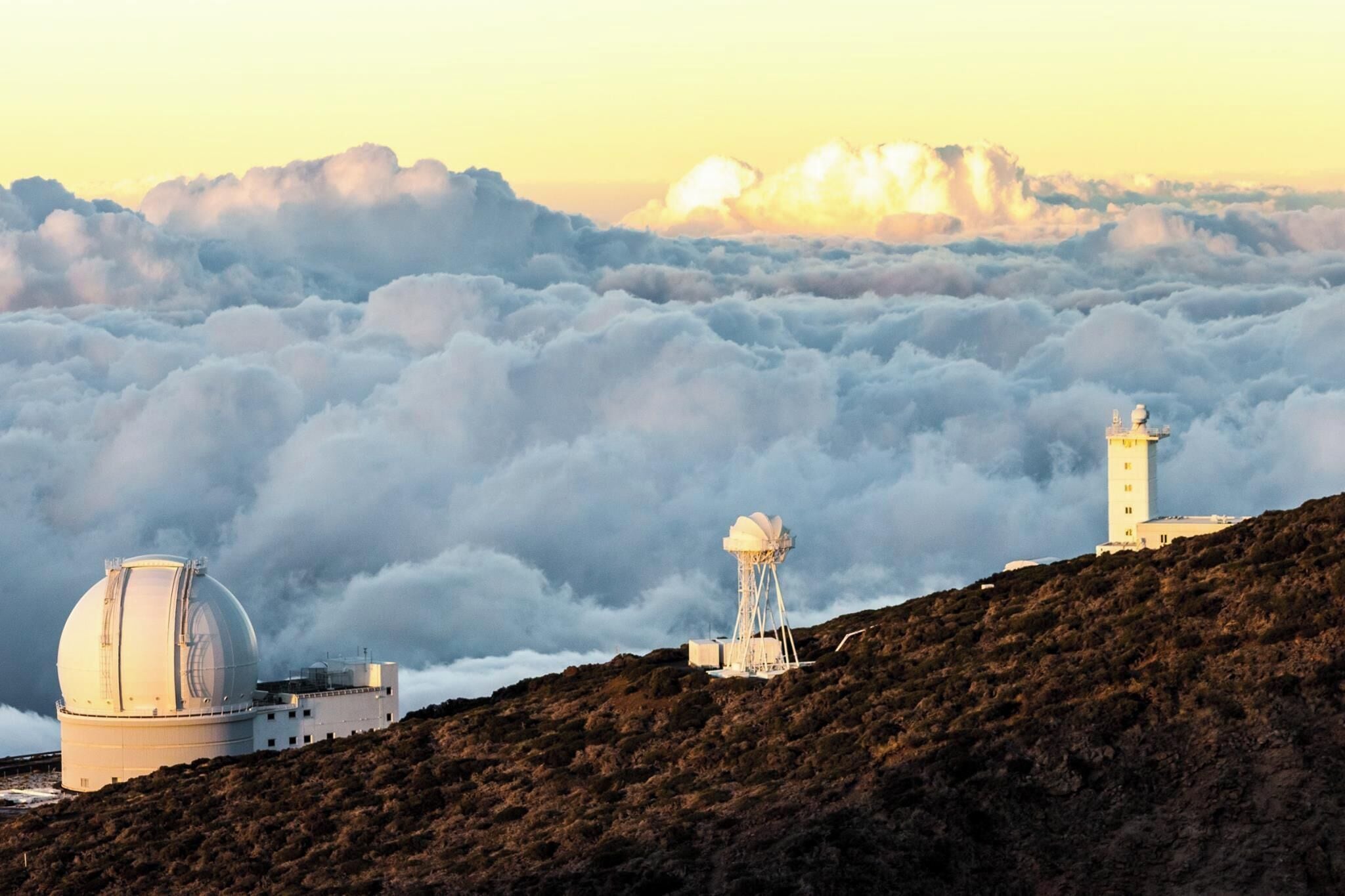 A mountainous landscape with a telescope and a water tower.