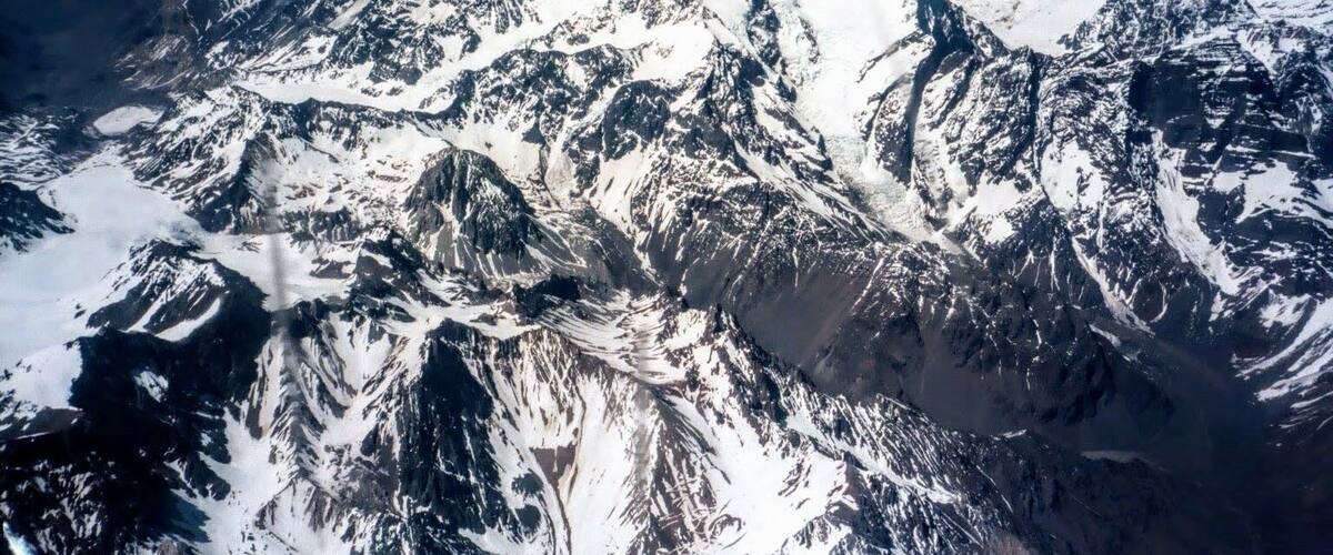 A snow-covered mountain range with rugged peaks and valleys.