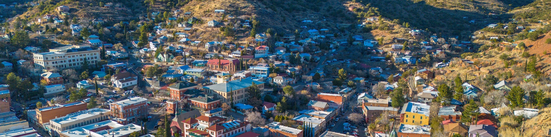 Un pueblo enclavado en un valle, con una colina destacada al fondo.