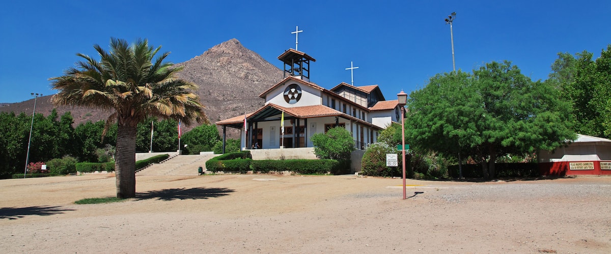 A church with a bell tower and a mountain in the background.
