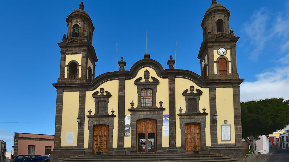 Eine historische Kirche mit zwei Glockentürmen, einer zentralen Kuppel und einer Uhr.