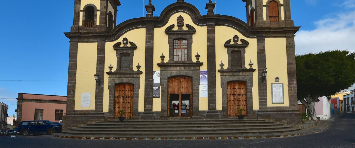 A historic church with two bell towers, a central dome, and a clock.