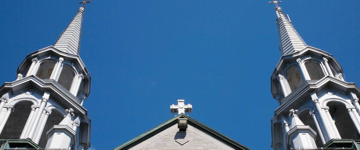 A church with two tall spires and a central cross.