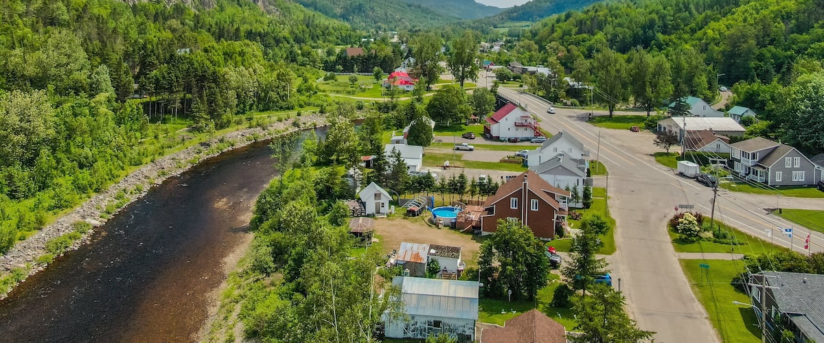 A river flowing through a town surrounded by mountains.