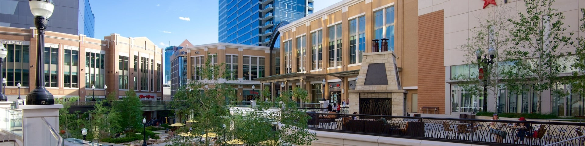 Um centro comercial com uma loja Macy's, área de estar externa e um edifício moderno ao fundo.