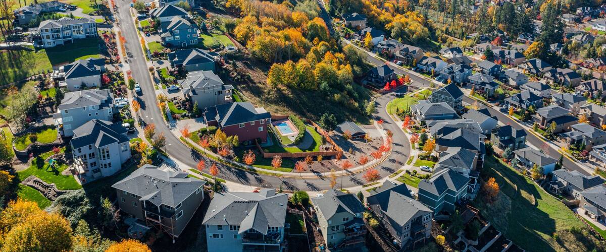 Aerial drone view of Happy Valley, Oregon, in autumn, showcasing vibrant fall foliage, residential neighborhoods, tree-lined streets, rolling hills, and suburban landscapes with golden and red leaves