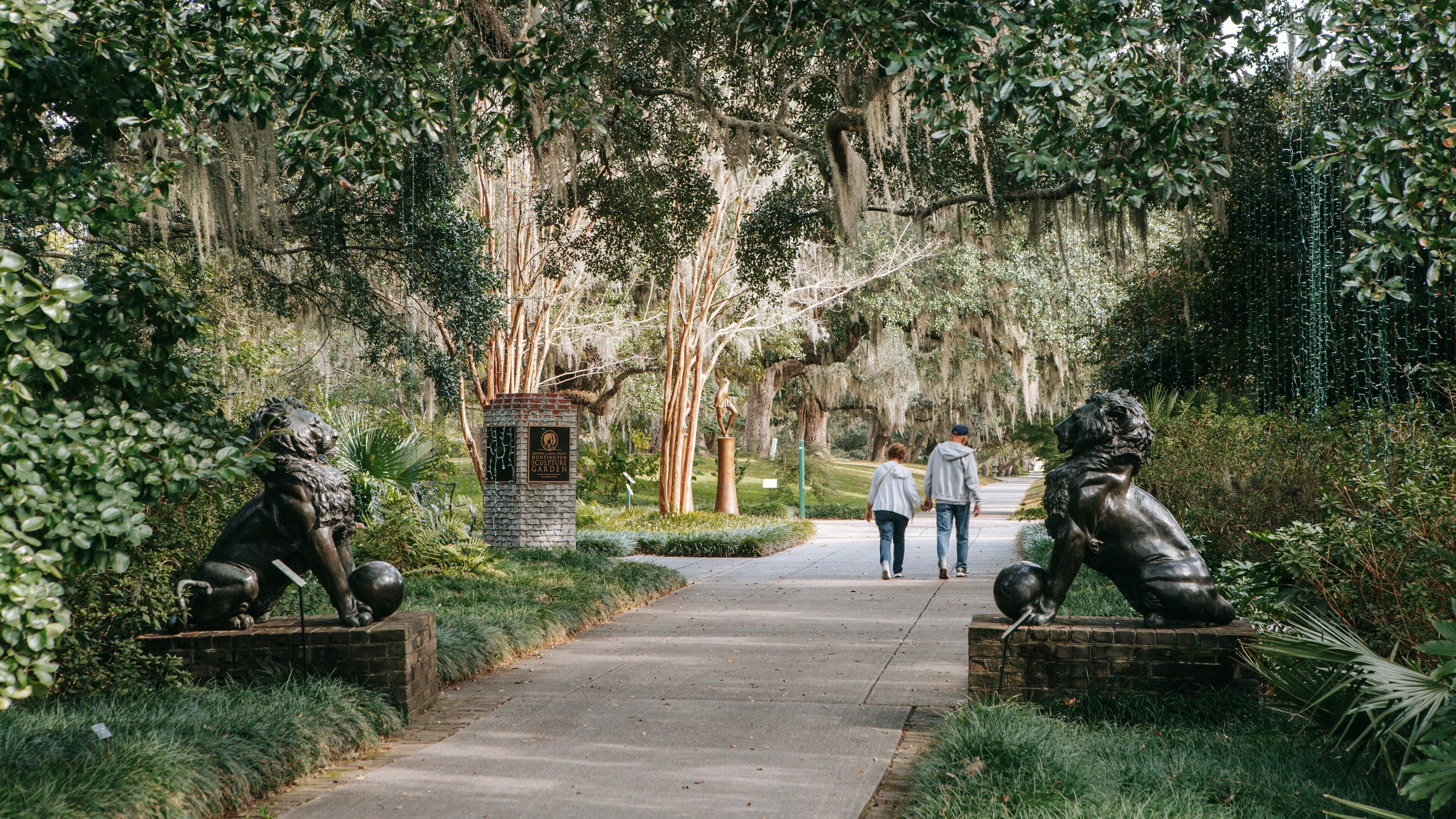 Brookgreen Gardens featuring a statue or sculpture and a garden as well as a couple