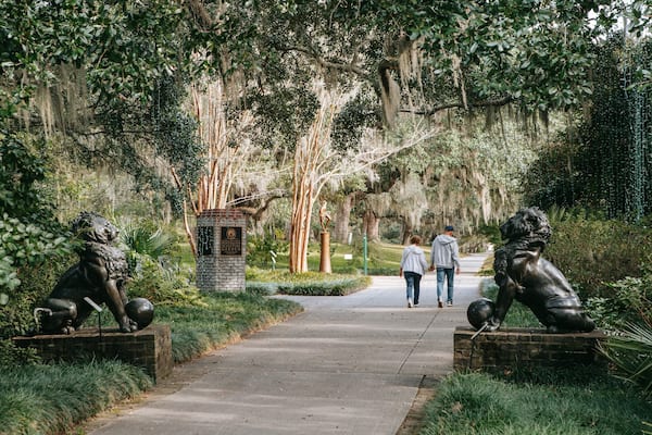 Brookgreen Gardens featuring a statue or sculpture and a garden as well as a couple